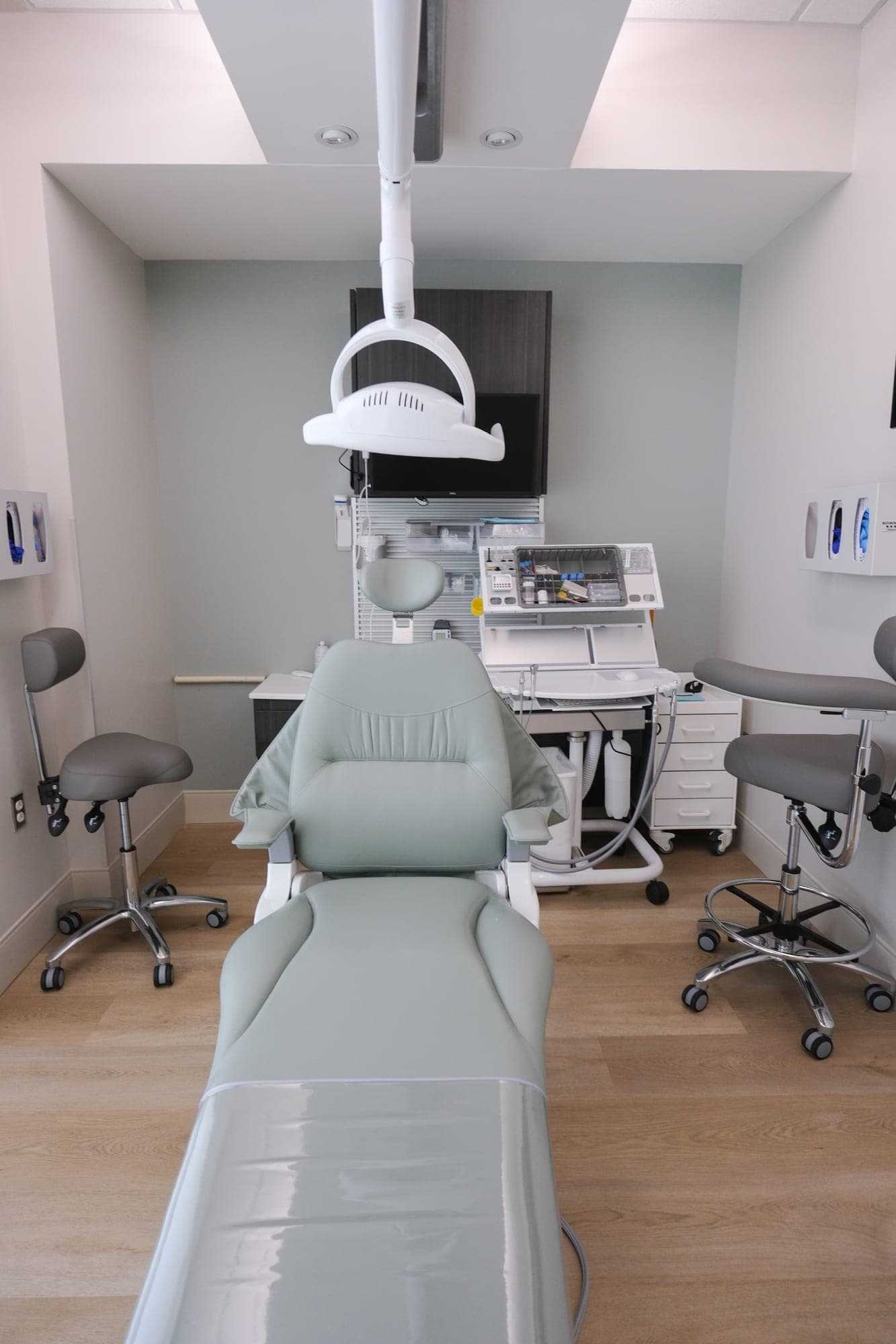 A treatment room seen head-on, its instrument tray and delivery unit laid out behind the chair