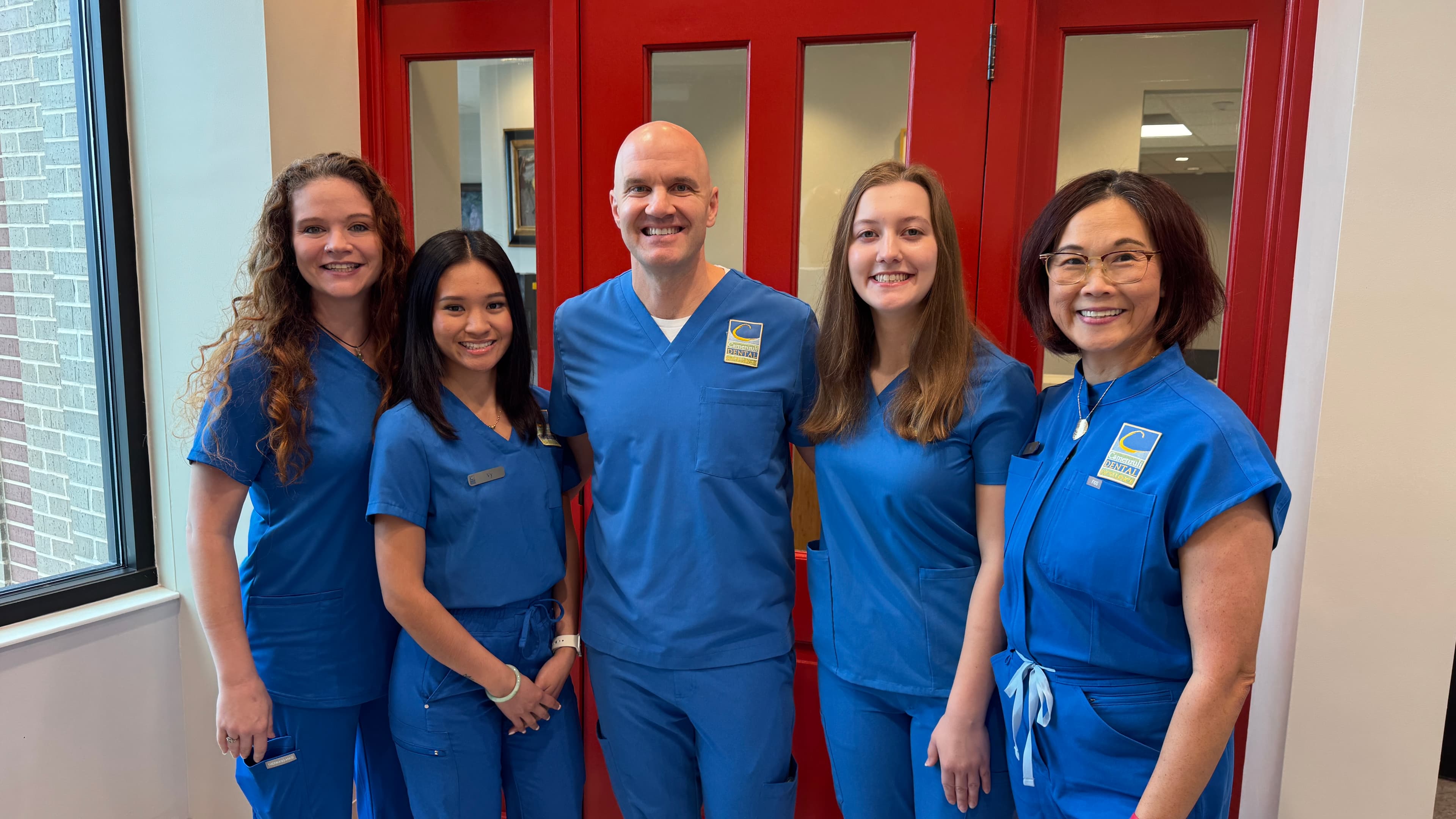 Dr. Camenzuli and the team at the signature red door of Camenzuli Dental Excellence