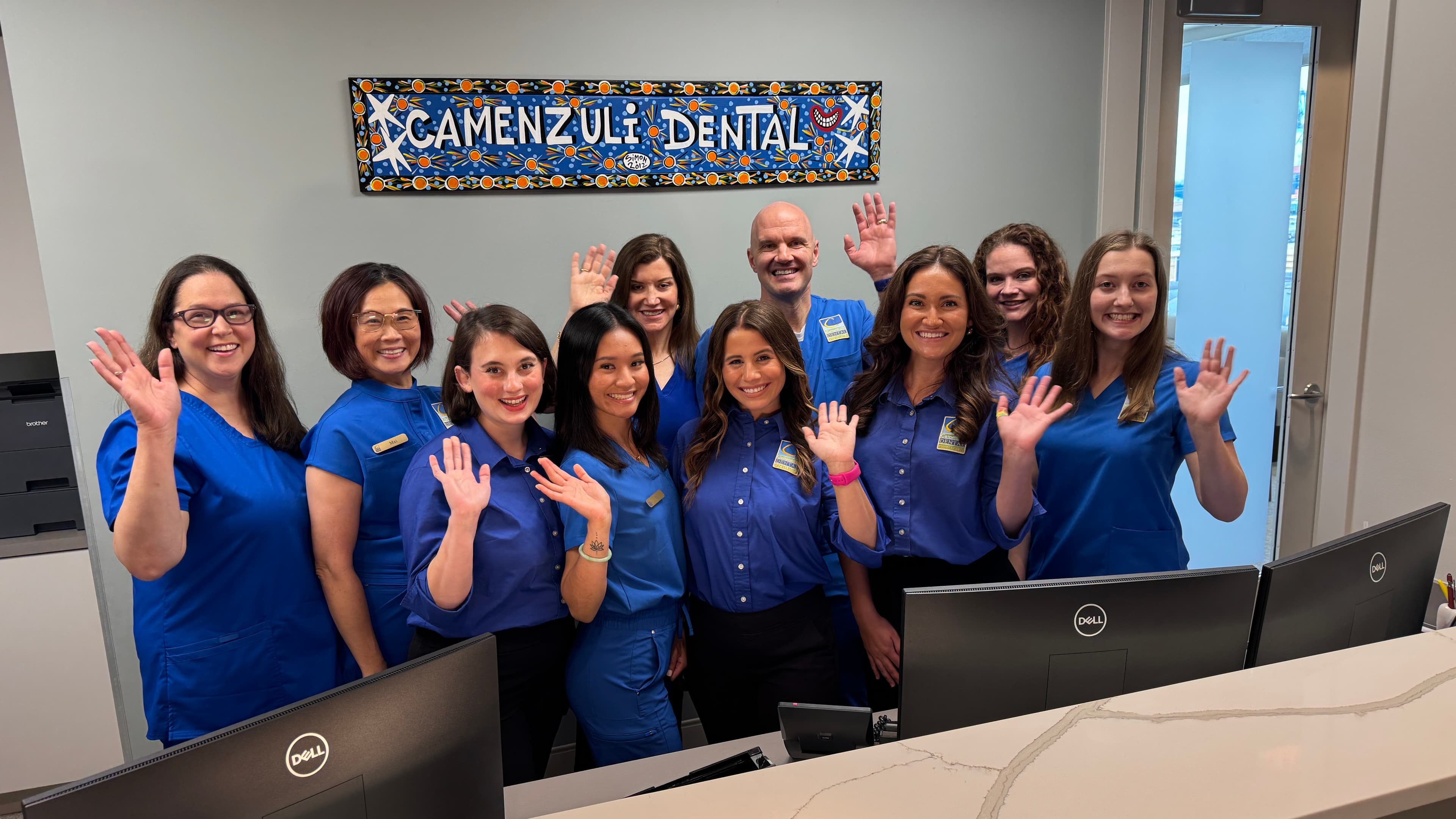 The team at Camenzuli Dental Excellence waving hello at the front desk