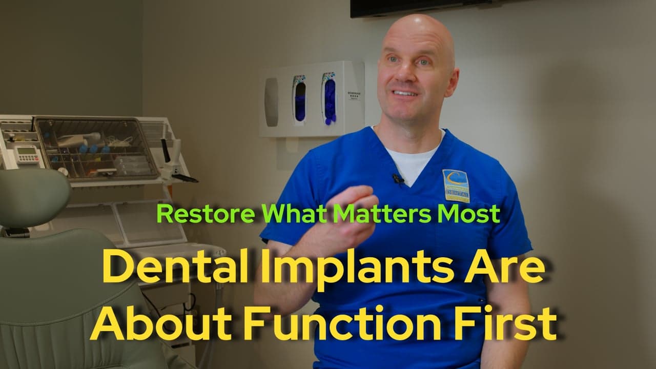 Dr. Robert Camenzuli in a treatment room, talking about dental implants