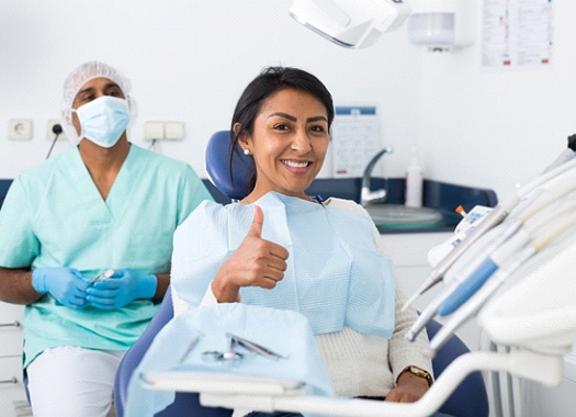 Woman gives thumbs up for dental anxiety treatment in Uptown New Orleans