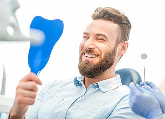 Man looking at smile in mirror