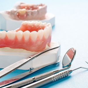 a plaster model of a mouth holding a full denture