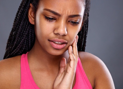 Woman in pain holding jaw