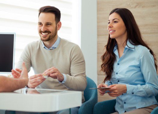 Smiling man and woman during dental consultation