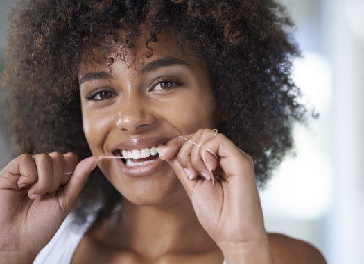 Woman flossing teeth