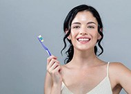 Woman with beautiful smile holding toothbrush