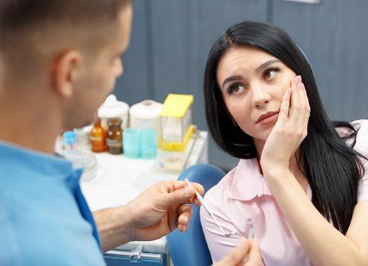 woman with toothache visiting emergency dentist in New Orleans