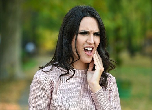 Woman in pain holding jaw