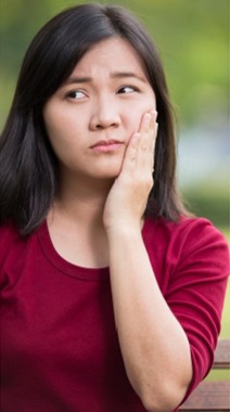 Woman holding her jaw in pain