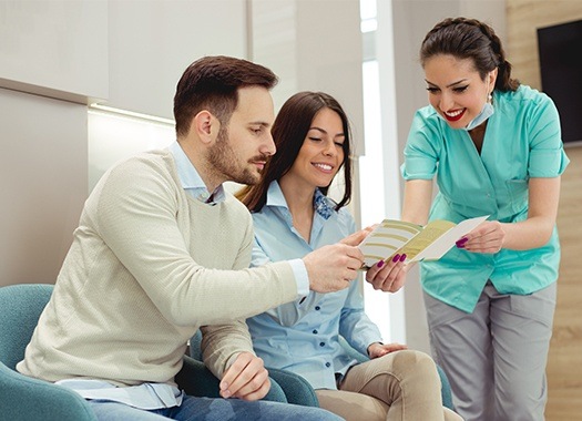 Man and woman talking to dental team member