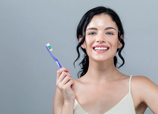 Woman with beautiful smile holding toothbrush
