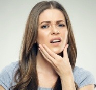 Woman in pain holding jaw