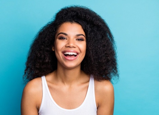 woman smiling against turquoise background