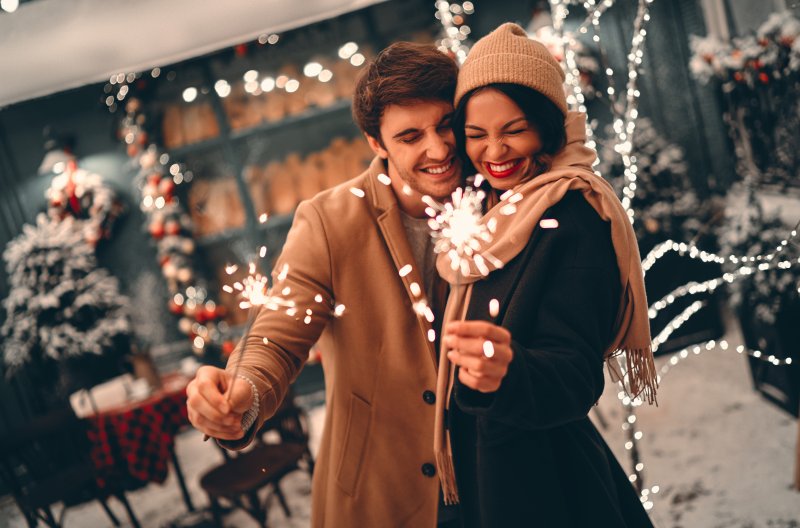 Smiling couple holding sparklers