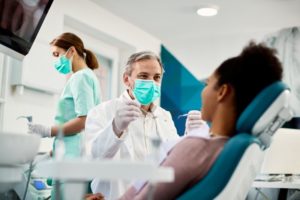 a dentist helping his patient at her checkup