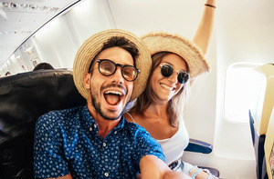 Man and woman smiling and sitting in airplane